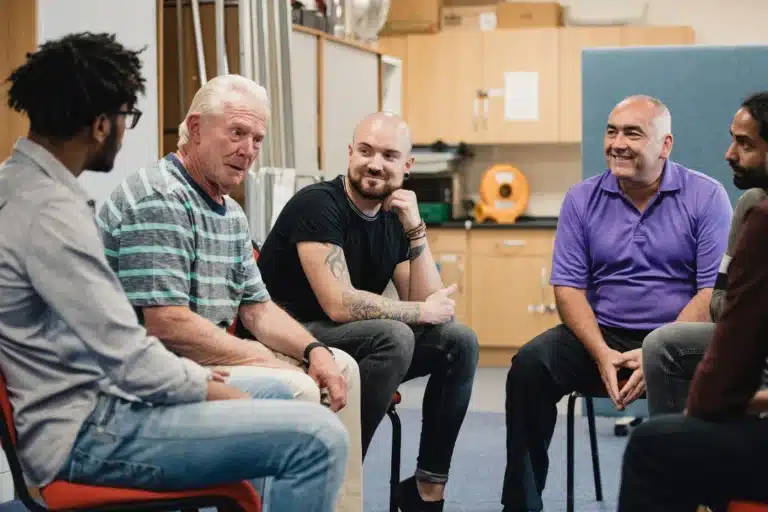 Group of diverse individuals seated in a supportive circle, engaging in an open and heartfelt discussion.