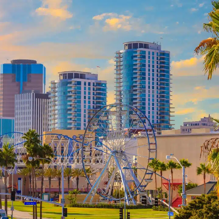 Colorful skyline of downtown Long Beach, California with high-rise buildings and Ferris wheel at sunset.
